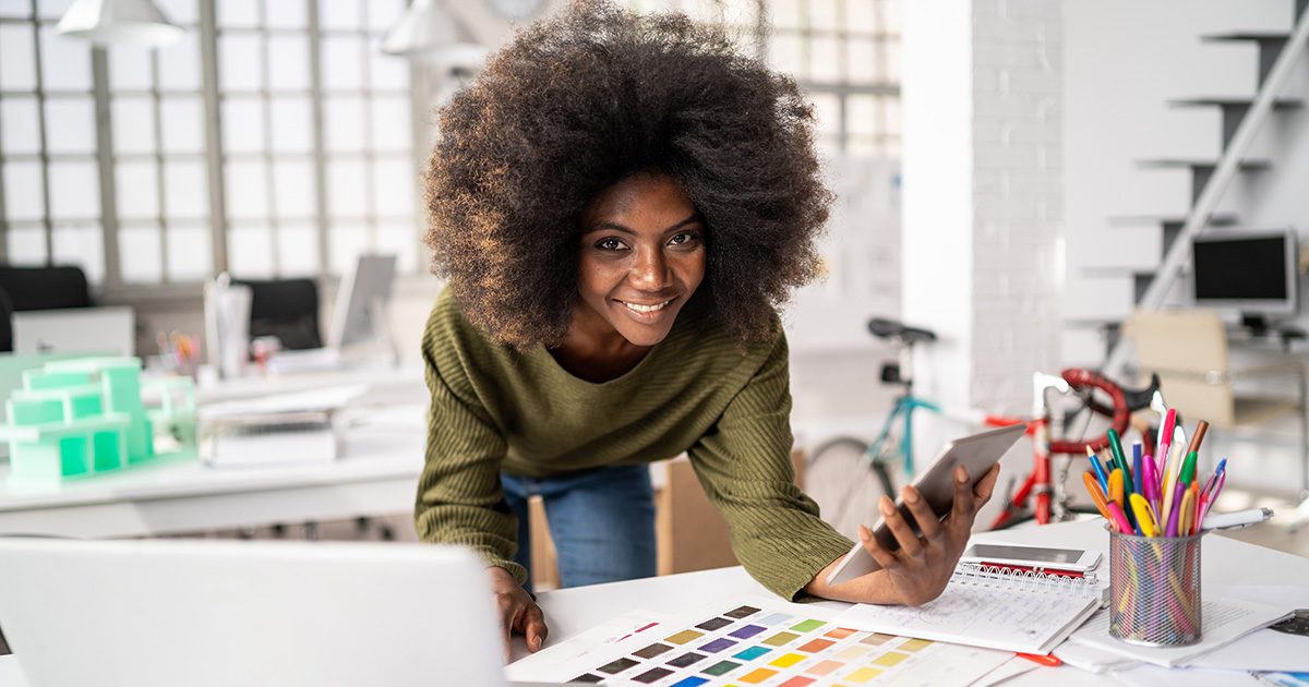 femme afro-américaine, magnifique et souriante, travaillant bureau avec charte de couleur graphiste