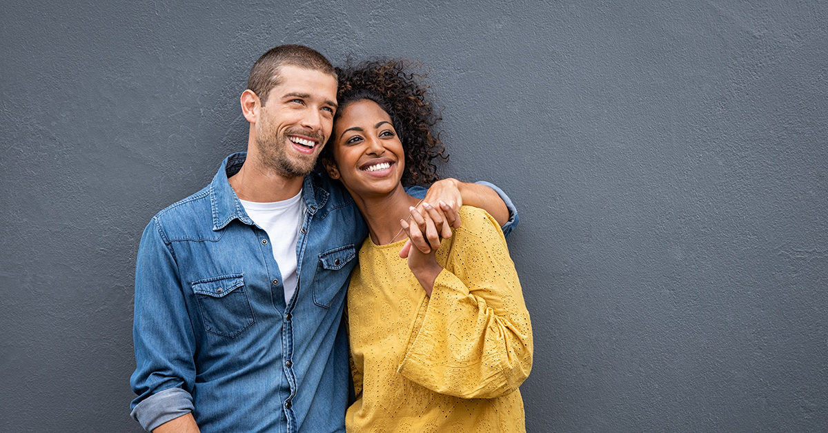 jeune couple souriant dans la trentaine homme caucasien femme afro-américaine